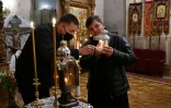 Des fidèles orthodoxes ukrainiens allument une chandelle avec le "feu saint" venu de Jérusalem au Monastère de la Laure de Petchersk à Kiev le 18 avril 2020