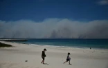 D'une plage proche de la petite station balnéaire de Forster, sur la côte est de l'Australie, on voit la fumée des nombreux incendies menaçant la ville, le 9 novembre 2019