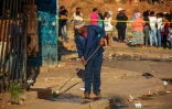 Un homme nettoie le 3 septembre 2019 à Johannesburg un trottoir tâché du sang de l'une des victimes des violences xénophobes en Afrique du Sud