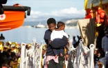 Photo fournie par la Croix rouge italienne d'une femme et son enfant débarquant à Vibo Marina, après avoir été secourues en mer Méditerranée, le 22 octobre 2016