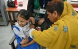 Une soignante (g) administre le vaccin contre le virus du papillome humain (VPH) à une adolescente, lors d'une campagne de vaccination contre le cancer du col de l'utérus, le 24 septembre 2025 à Islamabad, au Pakistan