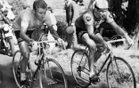 Le Français Jacques Anquetil (G), maillot jaune de leader, est au coude à coude avec son compatriote Raymond Poulidor dans l'ascension du Puy de Dôme, le 12 juillet 1964 lors de la 20ème étape du Tour de France, menant les coureurs de Brive à Clermont-Ferrand. A l'arrivée, Poulidor, 3ème, reprendra 42 secondes à Anquetil, insuffisant cependant pour empêcher le Normand de remporter à Paris son 5ème Tour de France.