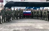 Image tirée d'une vidéo diffusée par le ministère russe de la Défense, le 9 juin 2025, de prisonniers de guerre russes tenant un drapeau russe devant un bus après un échange dans un lieu non divulgué au Bélarus