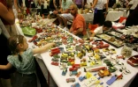 Des personnes chinent devant un stand de voitures miniatures, le 11 juin 2006 Porte de Versailles à Paris, où se tient la brocante géante d'Emmaüs, septième salon de l'association caritative fondée par l'Abbé Pierre