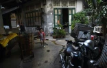 Une fillette joue le 12 avril 2016 dans une allée du quartier chinois de Bangkok, qui abrite des maisons anciennes, qui relèvent du patrimoine historique