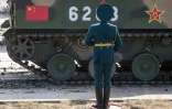 Un garde d'honneur russe devant un blindé chinois pendant l'exercice militaire Vostok-2018 à Tsugol, en Russie, en septembre 2018