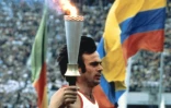 Un porteur de la flamme olympique court dans le stade central Lénine lors de la cérémonie des Jeux olympiques de Moscou en 1980, le 19 juillet 1980 à Moscou