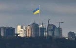 Un grand drapeau ukrainien flotte au dessus de Kiev attaqué par les forces russes, le 26 février 2022