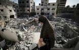 Une Palestinienne dans les décombres devant chez elle à Gaza, le 8 août 2022