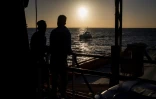 Deux migrants regardent le soleil se lever sur le pont du Sea Watch le 31 janvier 2019