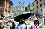 Des touristes se protègent de la chaleur avec des parapluies et des chapeaux, à Rome, le 26 mai 2026