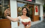 La Turque de 28 ans Ayse Keles prend un selfie devant le salon de coiffure où elle s'est rendue avant ses photos de mariage le 5 septembre 2020 à Istanbul