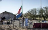 Une habitante d'Orania, Cara Tomlinson, hisse le drapeau de l'ancienne République sud-africaine au cimetière construit sur les lieux d'un camp de concentration de la guerre anglo-boer à Doornbult, près d'Orania, le 30 mai 2026.