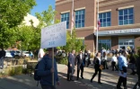 Un manifestant devant une file de candidats souhaitant travailler pour la police américaine de l'immigration (ICE), à Provo, dans l'Utah, le 15 septembre 2025
