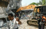 Un engin de chantier utilisé pour fouiller les décombres à la recherche de survivants dans un bâtiment détruit à Mandalay, le 29 mars 2025, au lendemain d'un puissant séisme en Birmanie
