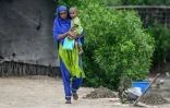 Une femme enceinte, en enfant dans les bras, arrive pour participer au programme de nutrition de l'Unicef au village de Fateh Muhammad Soomro, dans la province du Sindh, le 29 juillet 2025 au Pakistan