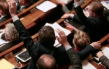 Des députés français votent à main levée des amendements à la constitution à l'Assemblée nationale française à Paris, le 9 février 2016