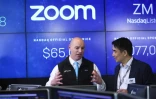 Le fondateur de Zoom, Eric Yuan (droite), parle avec un courtier au Nasdaq (New York) en avril 2019 lors de l'introduction en Bourse de sa société