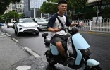 Un robotaxi (g), véhicule autonome sans chauffeur, du projet "Apollo Go" du géant technologique chinois Baidu, dans une rue de Wuhan, le 1er août 2024 dans la province chinoise du Hubei