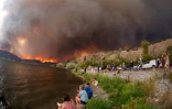 Des habitants observent les flammes des incendies à West Kelowna en Colombie-Britannique, au Canada, le 17 août 2023