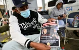 Un homme montre une photo d'une proche dont il attend des nouvelles à l'extérieur de la discothèque dont le toit s'est effondré deux jours auparavant à Saint-Domingue, le 10 avril 2025 en République dominicaine