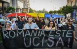 Des manifestants tiennent, le 27 juillet 2019 à Bucarest, une banderole sur laquelle on peut lire "La Roumanie est morte" après l'enlèvement et le meurtre d'une fillette qui ont profondément ému le pays provoquant le limogeage du chef de la police