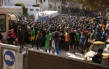 Des migrants attendent devant le centre d'accueil de Lampedusa, le 17 septembre 2023 en Italie