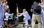Emmanuelle Assmann (C) porteuse de la flamme paralympique, le 24 août 2024 à Coquelles dans le Pas-de-Calais