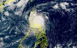 Image satellite colorisée publiée par l'agence météorologique japonaise (JMA) montrant le super typhon Man-yi en train de toucher terre sur l'île philippine de Luzon