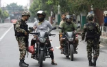 Des militaires contrôlent les pièces d'identité et documents de motocyclistes dans le cadre des mesures de sécurité imposées à Katmandou, le 10 septembre 2025 au Népal