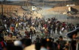 Des Palestiniens rassemblés à un point de distribution d'aide de la Fondation humanitaire de Gaza (GHF), près du camp de réfugiés de Nousseirat, dans le centre de la bande de Gaza, le 25 juin 2025