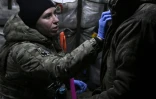 Vasylyna, assistante médicale ukrainienne pour la 80e brigade d’assaut, soigne un soldat blessé dans une fourgonnette médicalisée, dans la région de Donetsk, le 30 novembre 2023