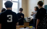 Oreste (c) et ses camarades de classe observent une minute de silence avec leur professeure de littérature, Nadia Cherekhor, à Kiev, le 13 octobre 2026 en Ukraine