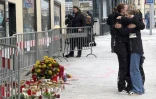 Des personnes s'étreignent devant les fleurs et bougies déposées en mémoire des victimes de l'attaque au couteau perpétrée par un demandeur d'asile syrien, qui a coûté la vie à un adolescent et blessé cinq autres personnes, le 16 février 2025 à Villach, dans le sud de l'Autriche