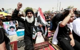 Des partisans bradissent des portraits du chef chiite Moqtada Sadr après la prière du vendredi, le 12 août 2022 à Bagdad 