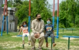 Aamir Gill (c), chrétien, et ses deux enfants, assis sur un banc dans un parc public, le 9 avril 2020 à Islamabad, au Pakistan