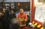 Le ministre de l'Intérieur Christophe Castaner (g) écoute un pompier devant les plans de l'immeuble incendié de la rue Erlanger à Paris, le 5 février 2019
