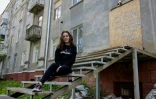 La reporter de guerre ukrainienne, Alina Yevych, assise sur les marches d'un bâtiment endommagé à Kramatorsk, dans la région de Donetsk, le 11 mai 2025