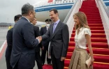 Photo diffusée par l'agence officielle syrienne Sana montrant le président syrien Bachar al-Assad (c) et la Première dame Asma al-Assad (d) à leur arrivée à l'aéroport de Pékin, le 21 septembre 2023