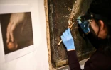 La restauratrice d'art Sophie Jarrosson travaille sur un tableau qui pourrait être une version authentique du tableau "Atalante et Hippomène" du peintre baroque italien du XVIIe siècle Guido Reni, lors d'une présentation à la presse à Libourne, le 25 février 2025 en Gironde