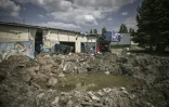 Un cratère apparait devant un supermarché détruit à Soledar dans le sud de l'Ukraine le 24 mai 2022 