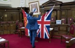 L'officier d'Etat civil d'Islington, Dion Goncalves, installe un portrait de la reine Elizabeth II avant une cérémonie d'allégeance de nouveaux citoyens britanniques, le 5 février 2018