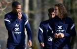 Le gardien de but Mike Maignan (g.) discute avec le milieu de terrain Matteo Guendouzi (d.), avant une séance d'entraînement de l'équipe de France à Clairefontaine-en-Yvelines près de Paris, le 27 mars 2022