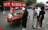 Des gens font la queue pour acheter de la nourriture à un vendeur de rue installé sur un carrefour à Pékin, le 9 juin 2020