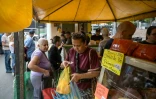 Des personnes font leurs courses sur un marché de rue à Caracas, le 20 décembre 2025 au Venezuela