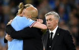 L'entraîneur de Manchester City Pep Guardiola (c) dans les bras de son attaquant Erling Haaland sous les yeux de l'entraîneur du Real Carlo Ancelotti (d), le 17 mai 2023 à Manchester    