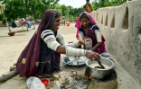 Jamna Kolhi (g) et sa parente Reshma, portant des tatouages et des tenues indigènes, préparent du thé au village de Ponjo Kolhi, à environ 30 km d'Umerkot, un district à majorité hindoue, le 14 juillet 2025 au Pakistan