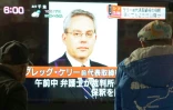 Des piétons passent devant un écran de télévision sur lequel apparaît le visage de de Greg Kelly, ancien bras droit de Carlos Ghosn, le 21 décembre 2018 à Tokyo, au Japon