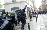 Un CRS lance une grenade lacrymogène contre des manifestants en marge du défilé syndical du 1er mai 2018 à Paris