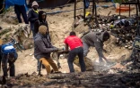 Des migrants s'activent pour remettre de l'ordre dans la "Jungle" de Calais le 27 mai 2016 au lendemain d'une importante rixe qui a fait 40 blesséz